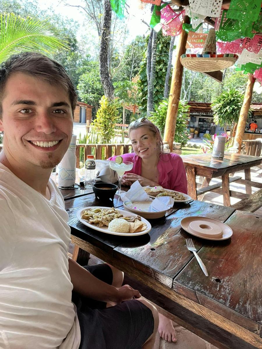 Un hombre y una mujer sentados en una mesa con comida.