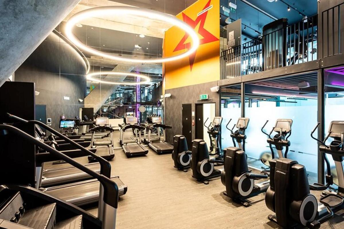 une salle de sport avec un tas de tapis de course et de machines