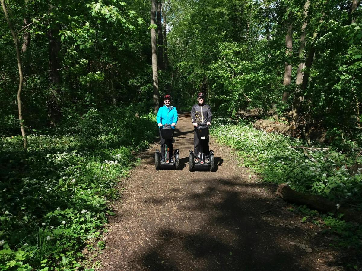kaks inimest sõidavad Segwaydega mööda kruusateed