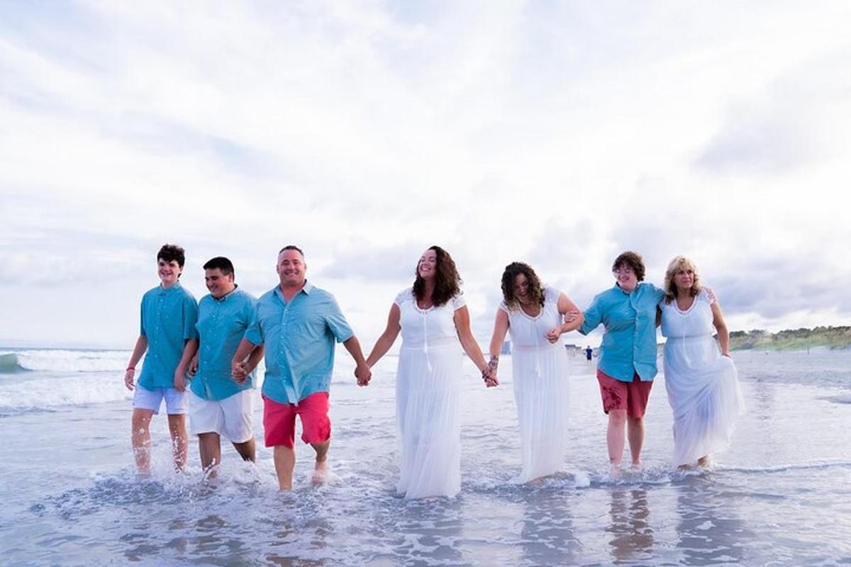 a group of people walking in the water on the beach