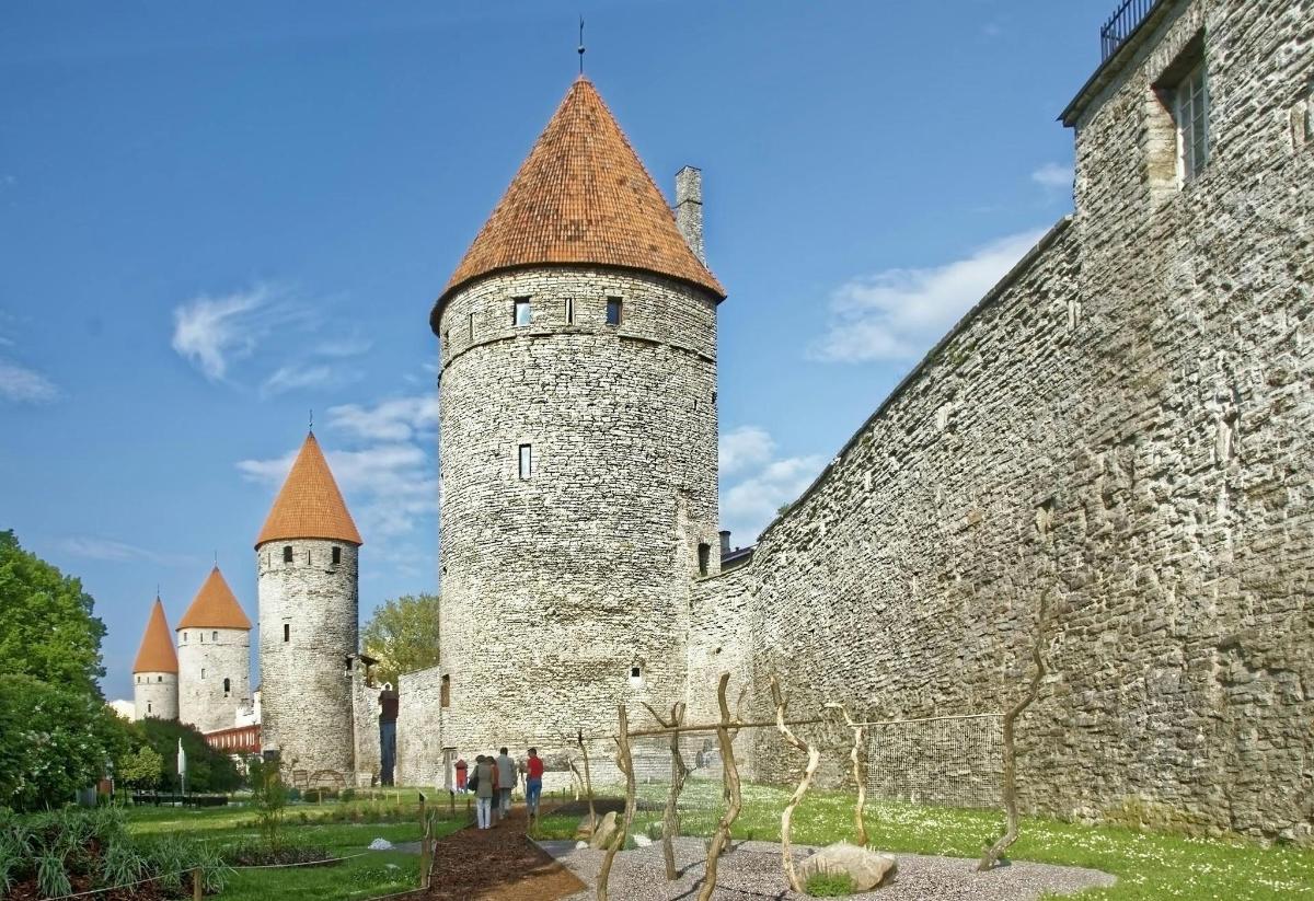 two towers of a castle with people standing near it