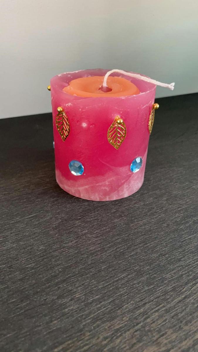 růžová svíčka sedící na stole