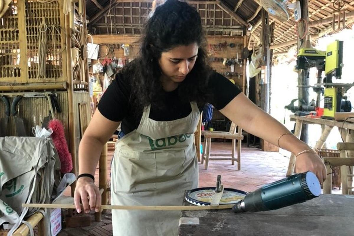 eine Frau in einer Schürze schneidet ein Stück Holz