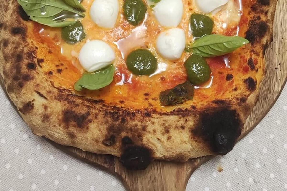 una pizza appoggiata su un tagliere di legno