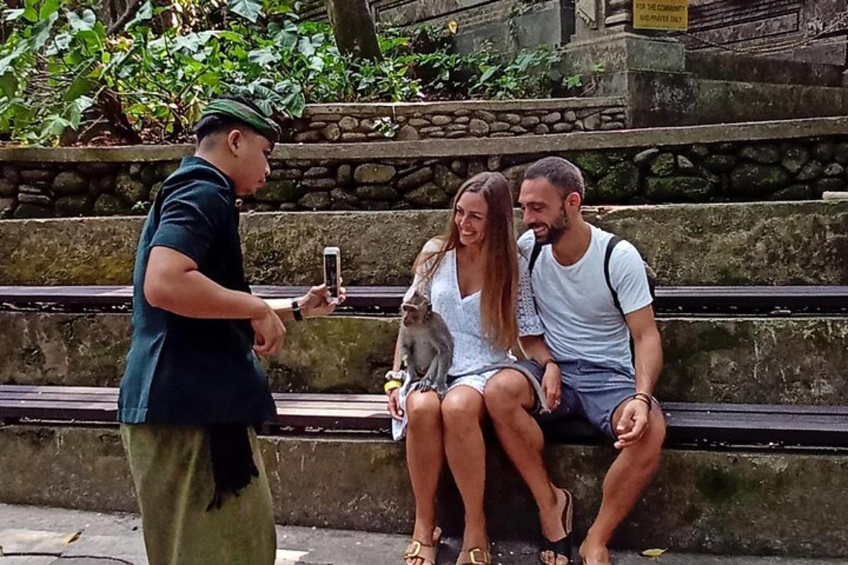 seorang lelaki mengambil gambar dua orang dan seekor anjing