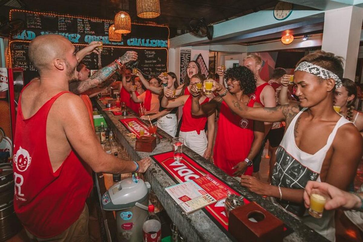 un gruppo di persone in piedi attorno a un bar con dei drink