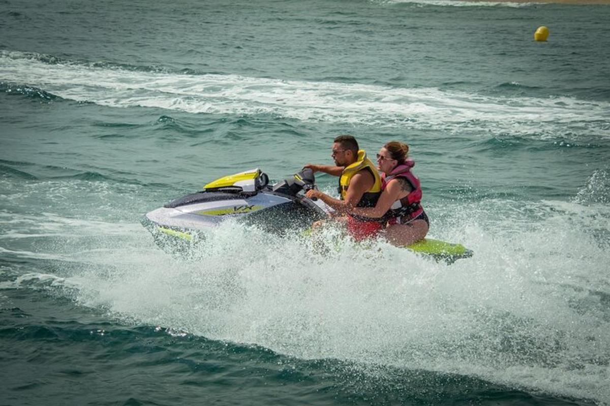 Dos personas viajando en una moto acuática en el agua