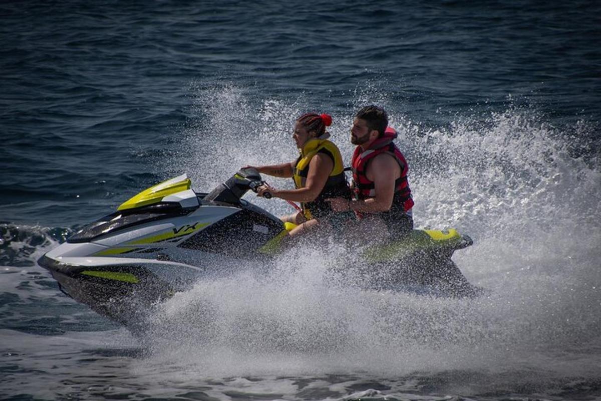 Dos personas viajando en una moto acuática en el agua