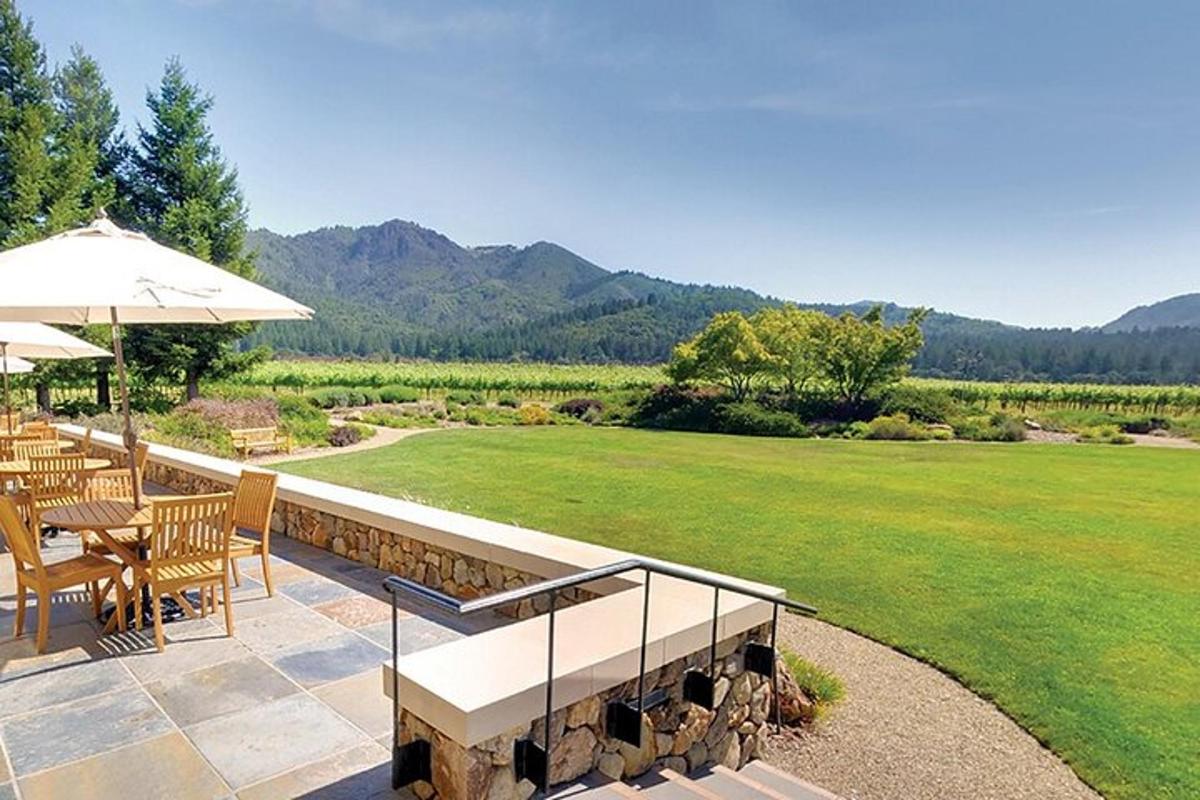 eine Terrasse mit Tisch und Stühlen und einem Sonnenschirm