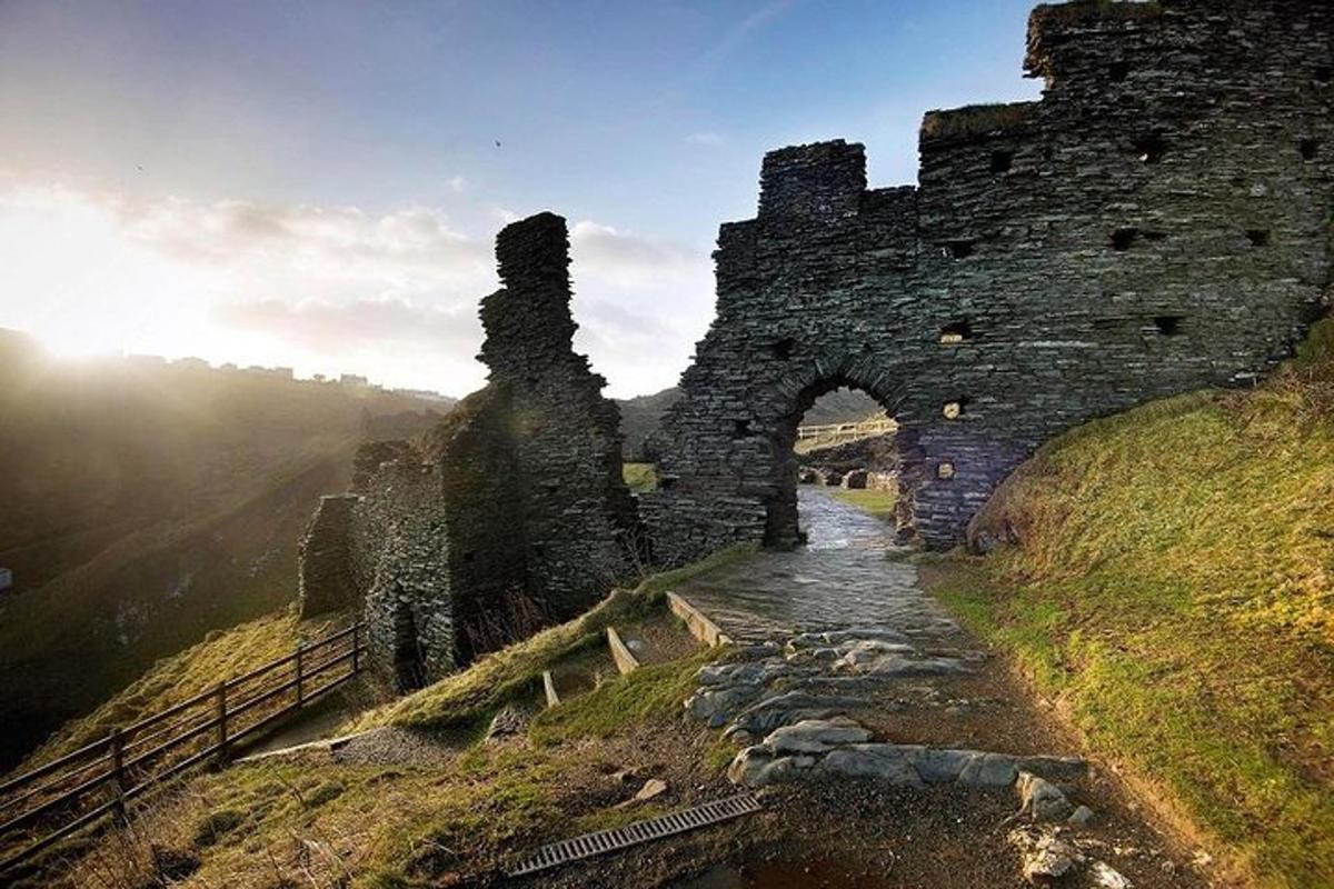 an old stone building on a hill with a bridge
