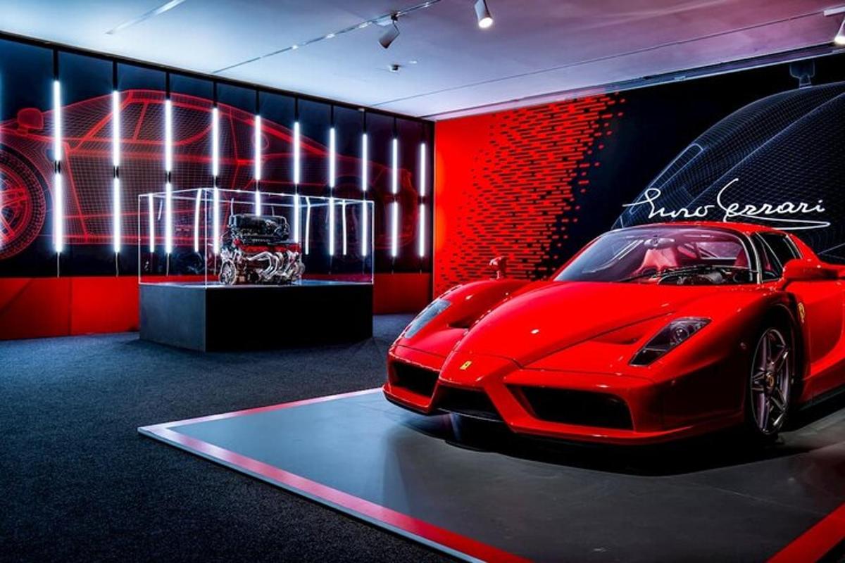 une voiture rouge est exposée dans une pièce