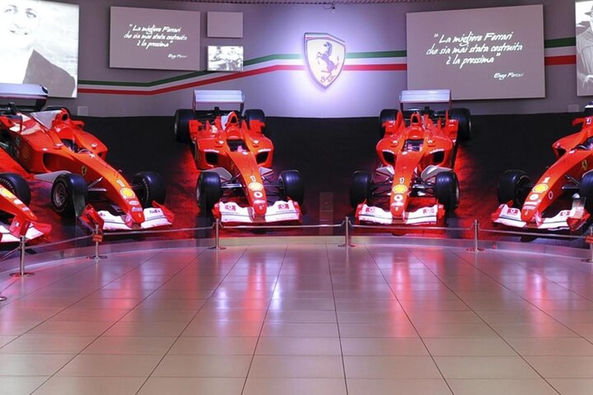 une salle avec deux voitures de course rouges exposées