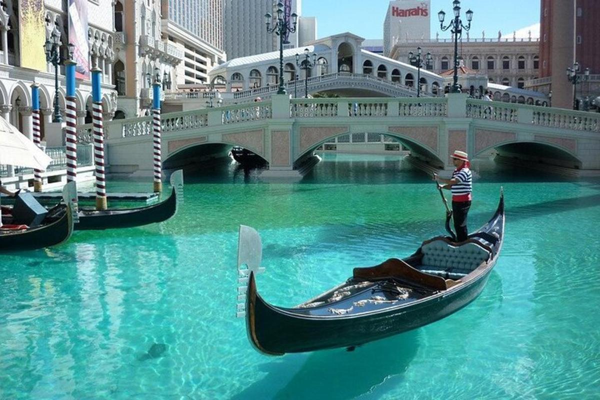 seorang pria mengendarai gondola di air dekat jembatan