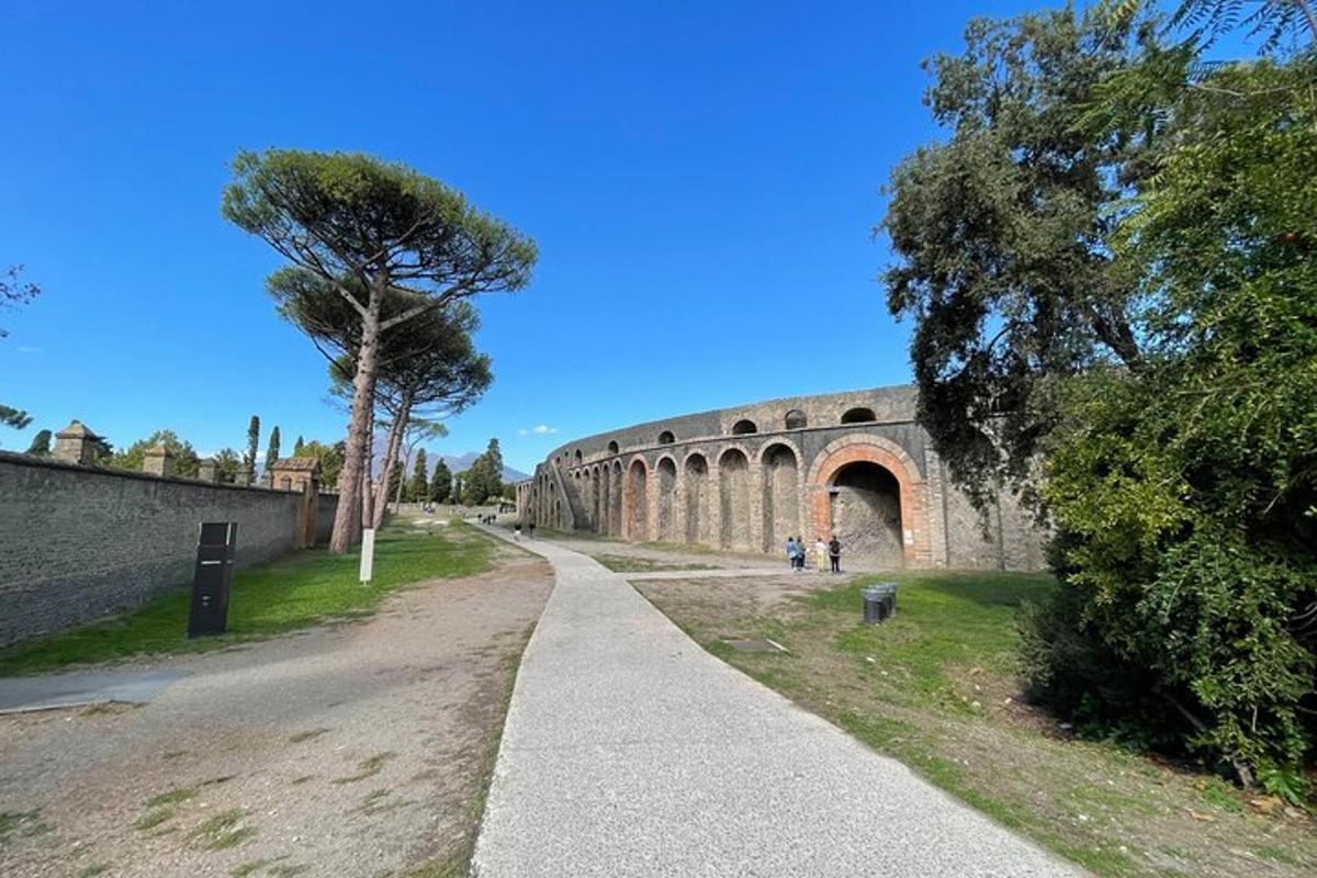 uma ponte de pedra com uma árvore ao lado de uma estrada