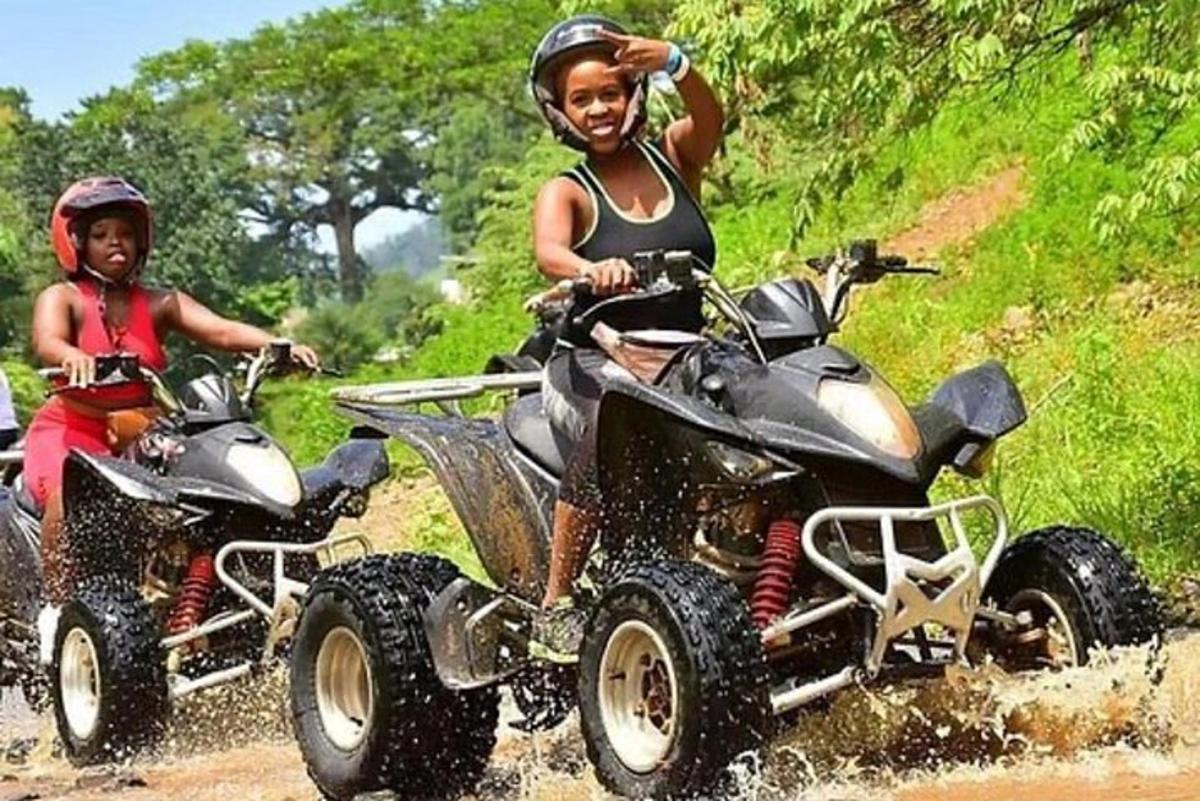 dalawang batang babae na nakasakay sa mga atv sa isang maruming kalsada