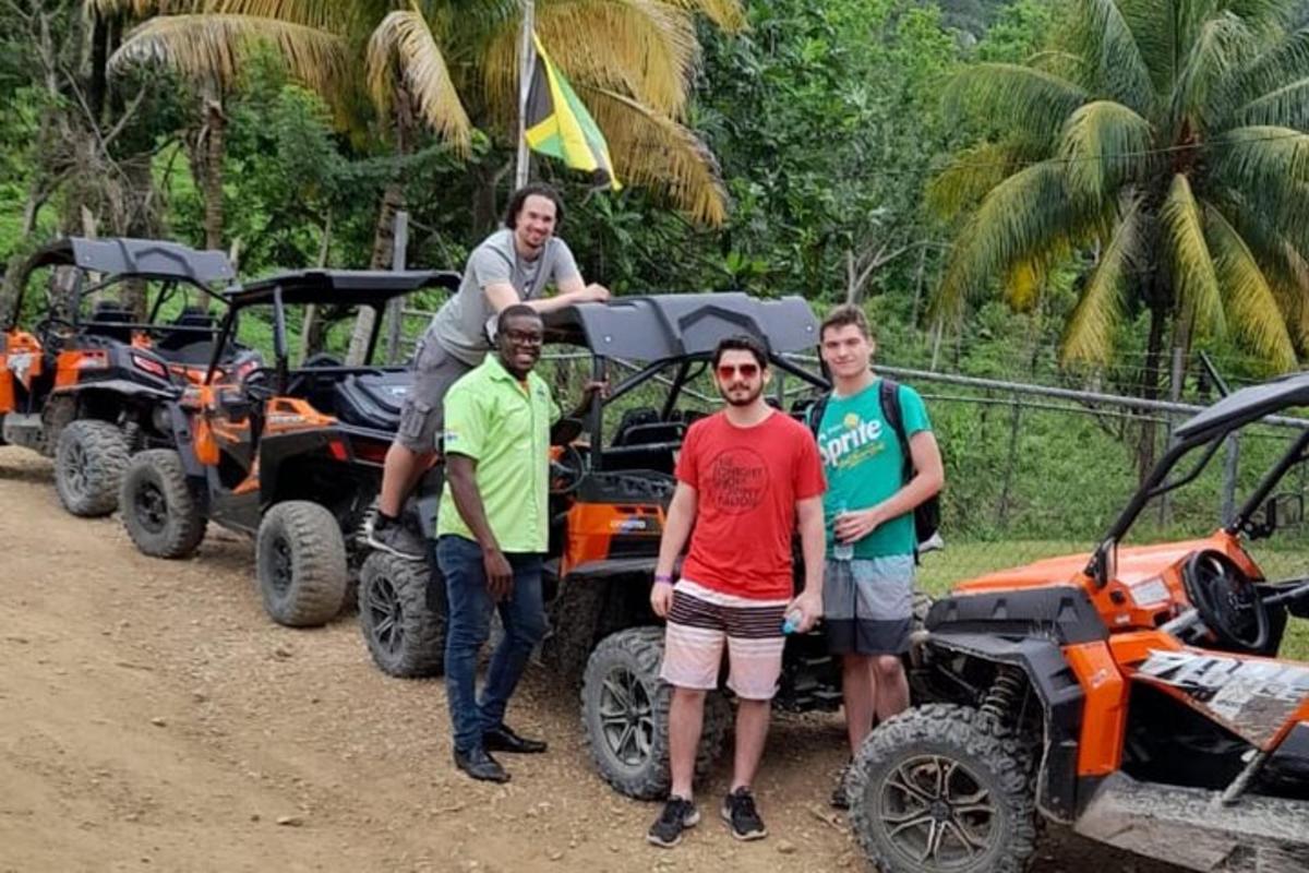 isang grupo ng mga lalaki na nakatayo sa harap ng apat na atv