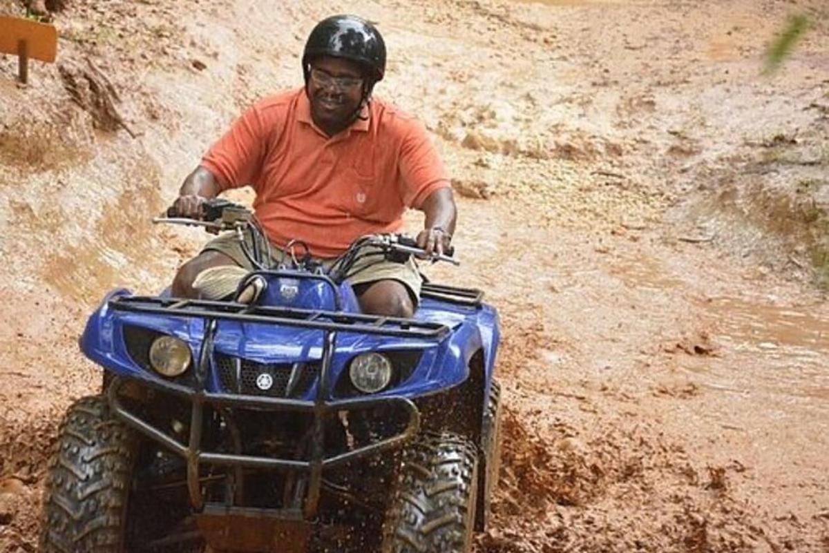 isang lalaking nakasakay sa isang four wheeler sa putikan