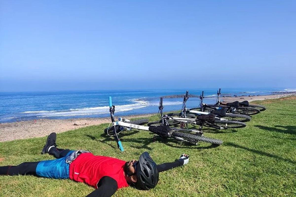 um homem deitado na grama ao lado de uma fileira de bicicletas