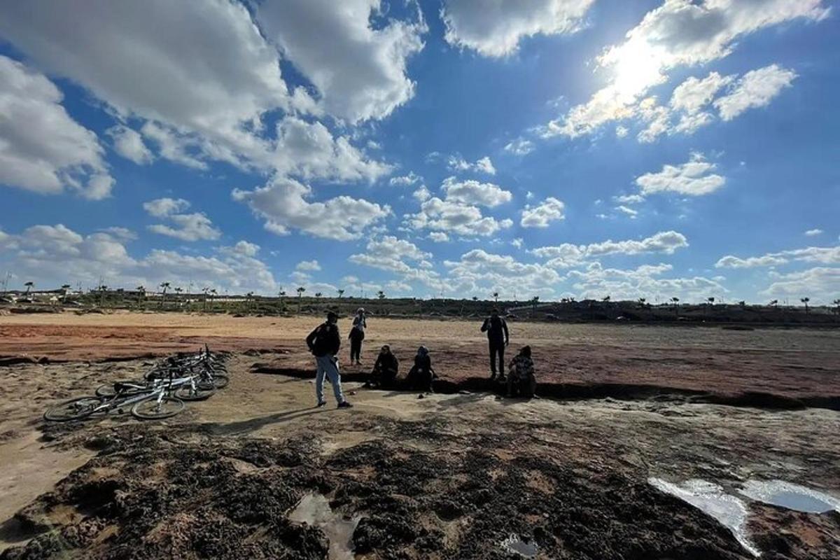 un gruppo di persone in piedi su un campo sterrato