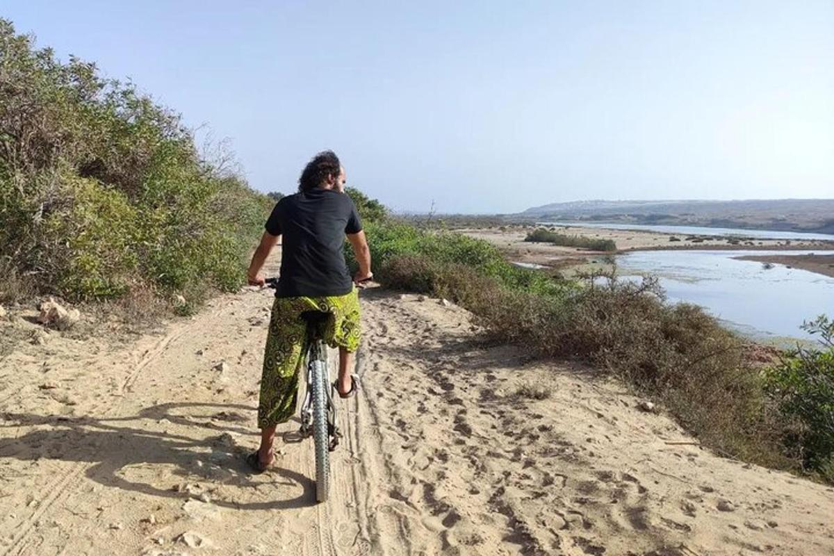 un uomo in bicicletta su una strada sterrata
