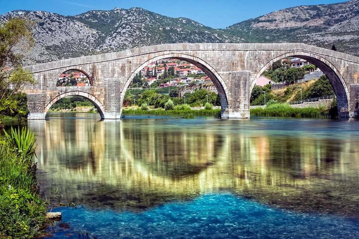un ponte sopra un fiume con le montagne sullo sfondo
