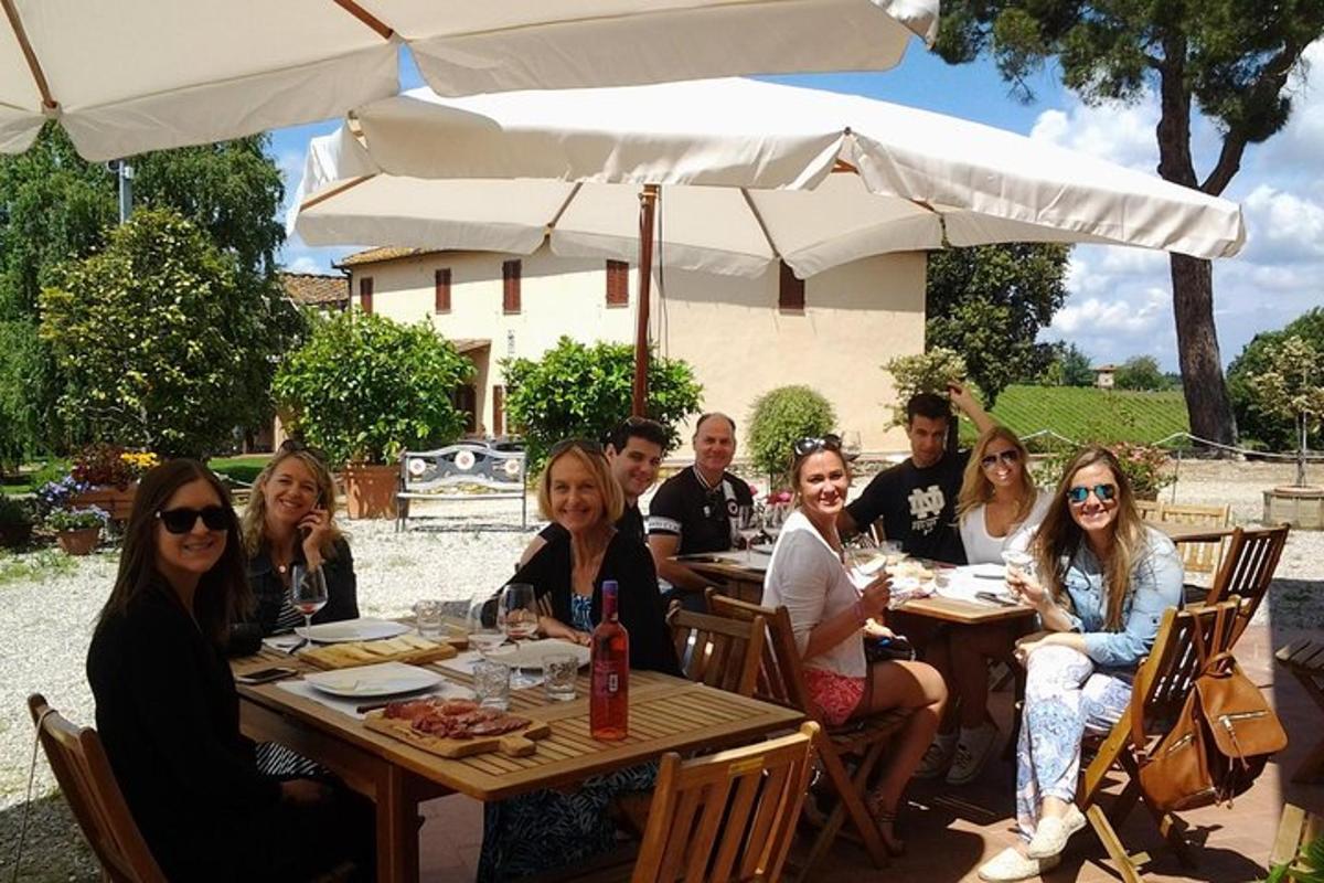 a group of people sitting at a table under an umbrella
