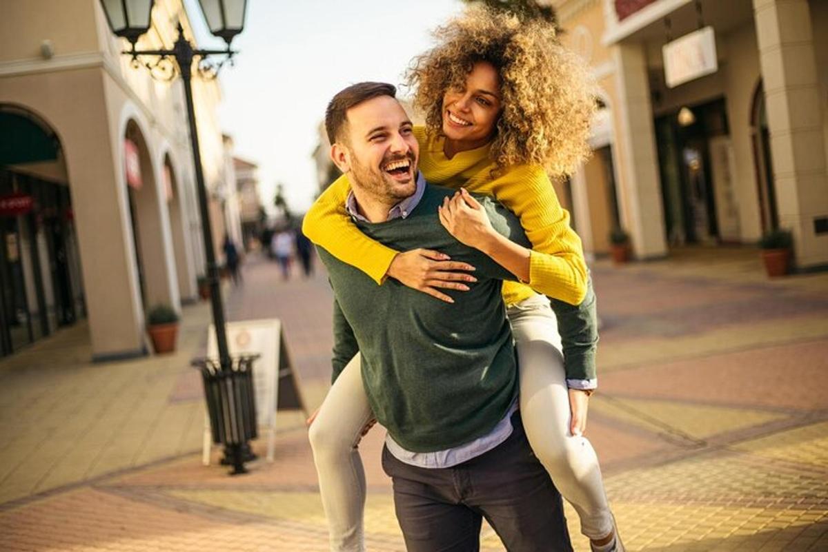 um homem carregando uma mulher nas costas em uma rua