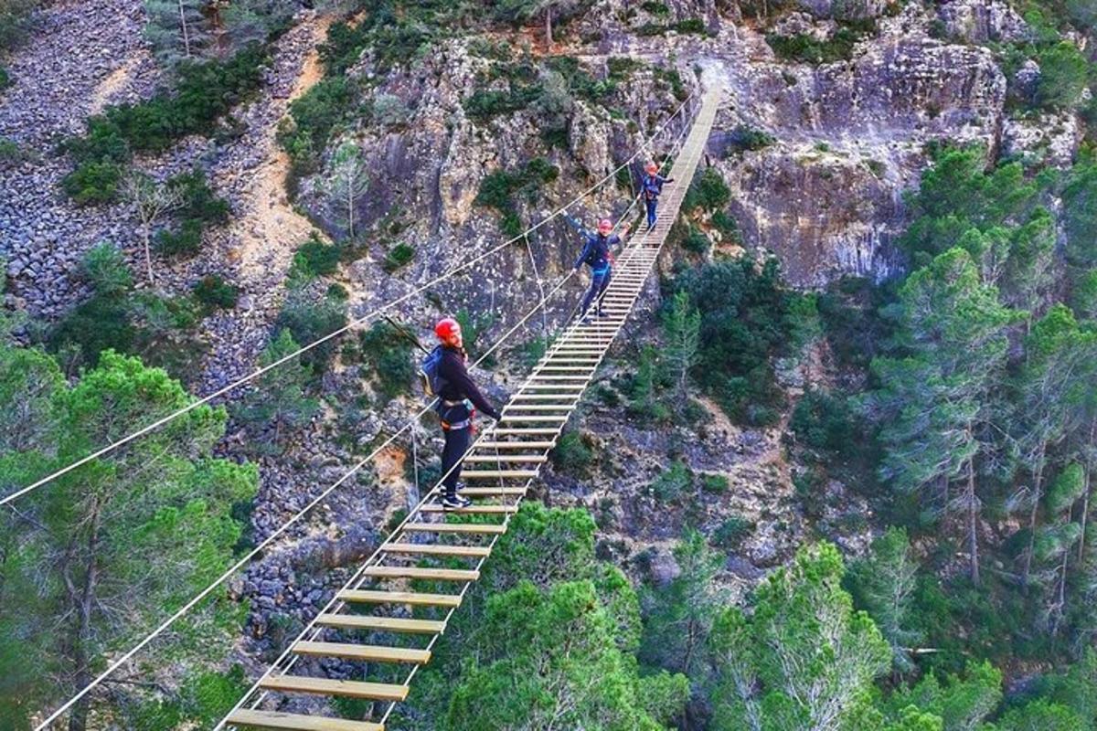 Dos personas caminando sobre un puente de cuerda sobre una escalera.