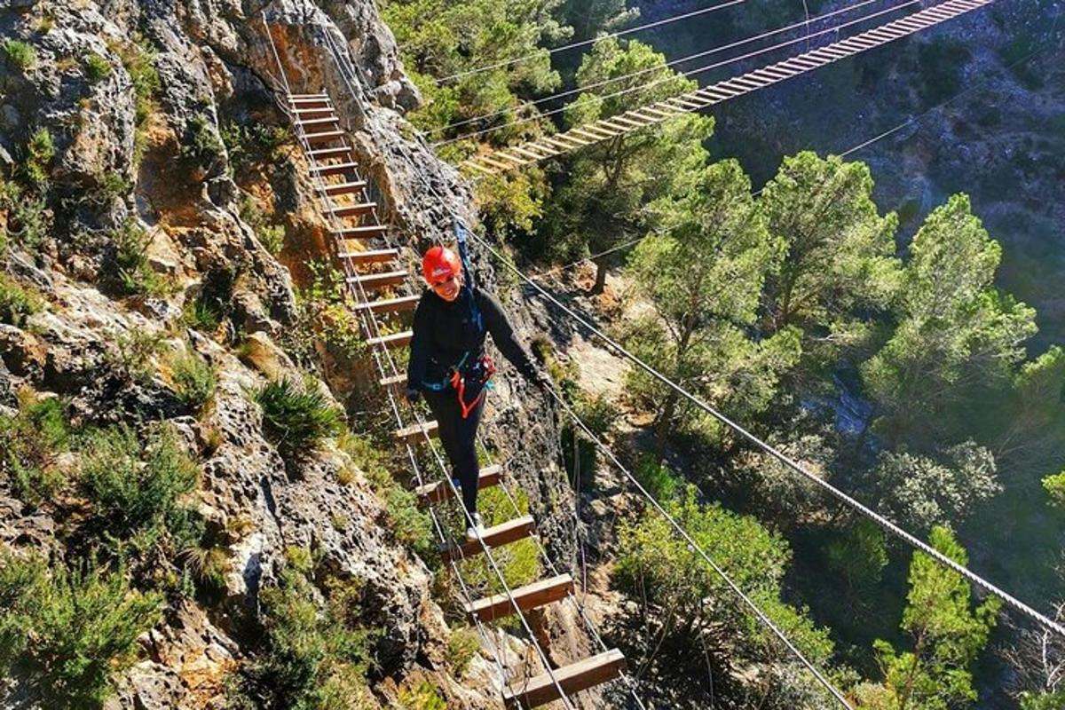 ένα άτομο που περπατά σε μια κρεμαστή γέφυρα σε ένα βουνό
