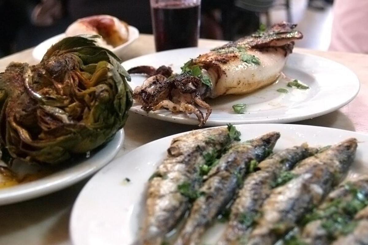 una taula amb tres plats de menjar amb peix i verdures