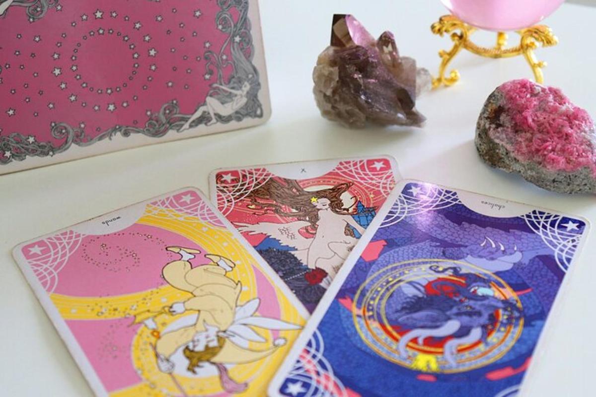 một cái bàn có ba lá bài tarot và một ít bánh rán