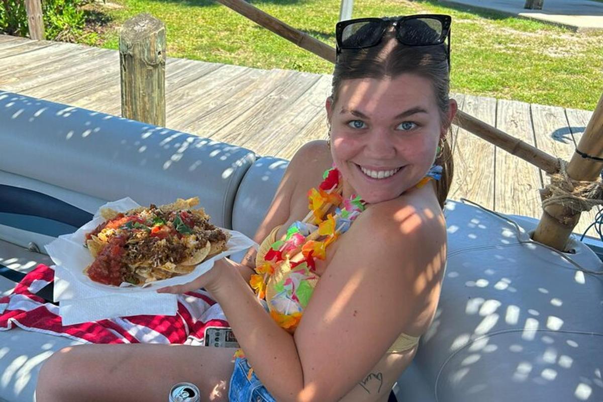 a woman sitting in an inflatable pool with a hot dog