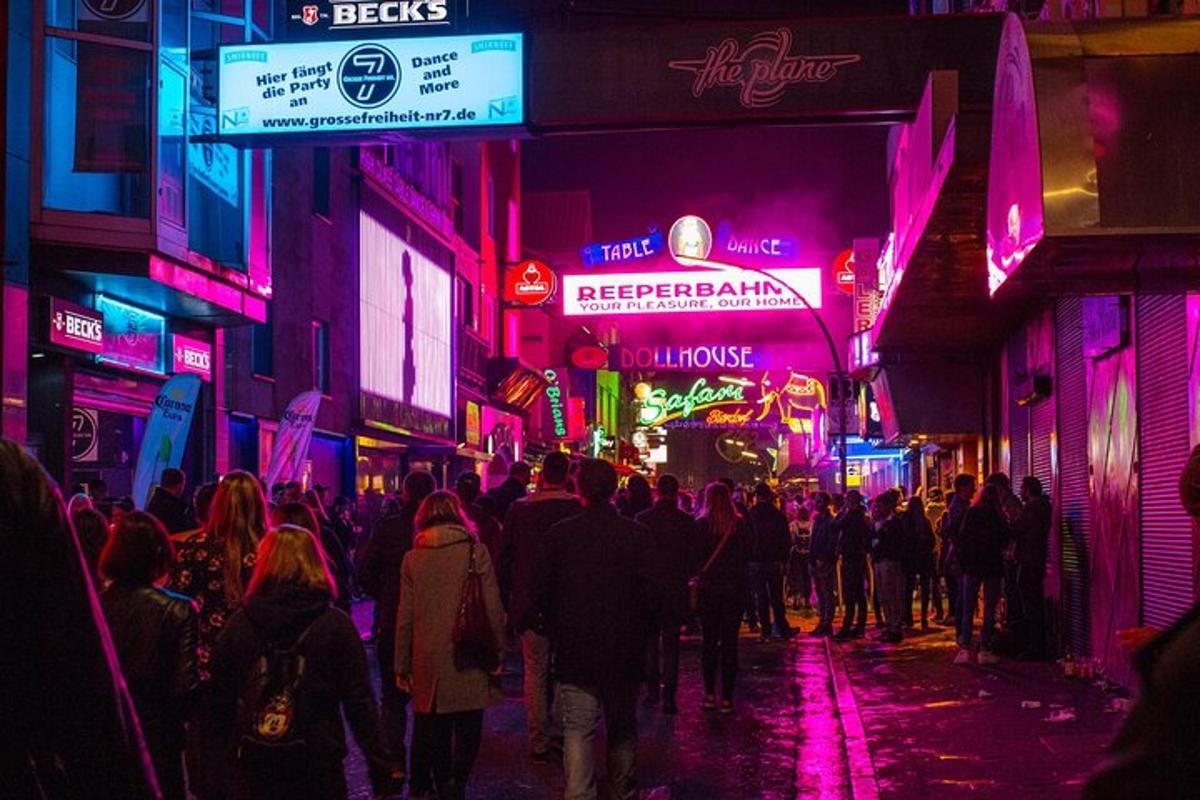uma multidão de pessoas caminhando pela rua à noite
