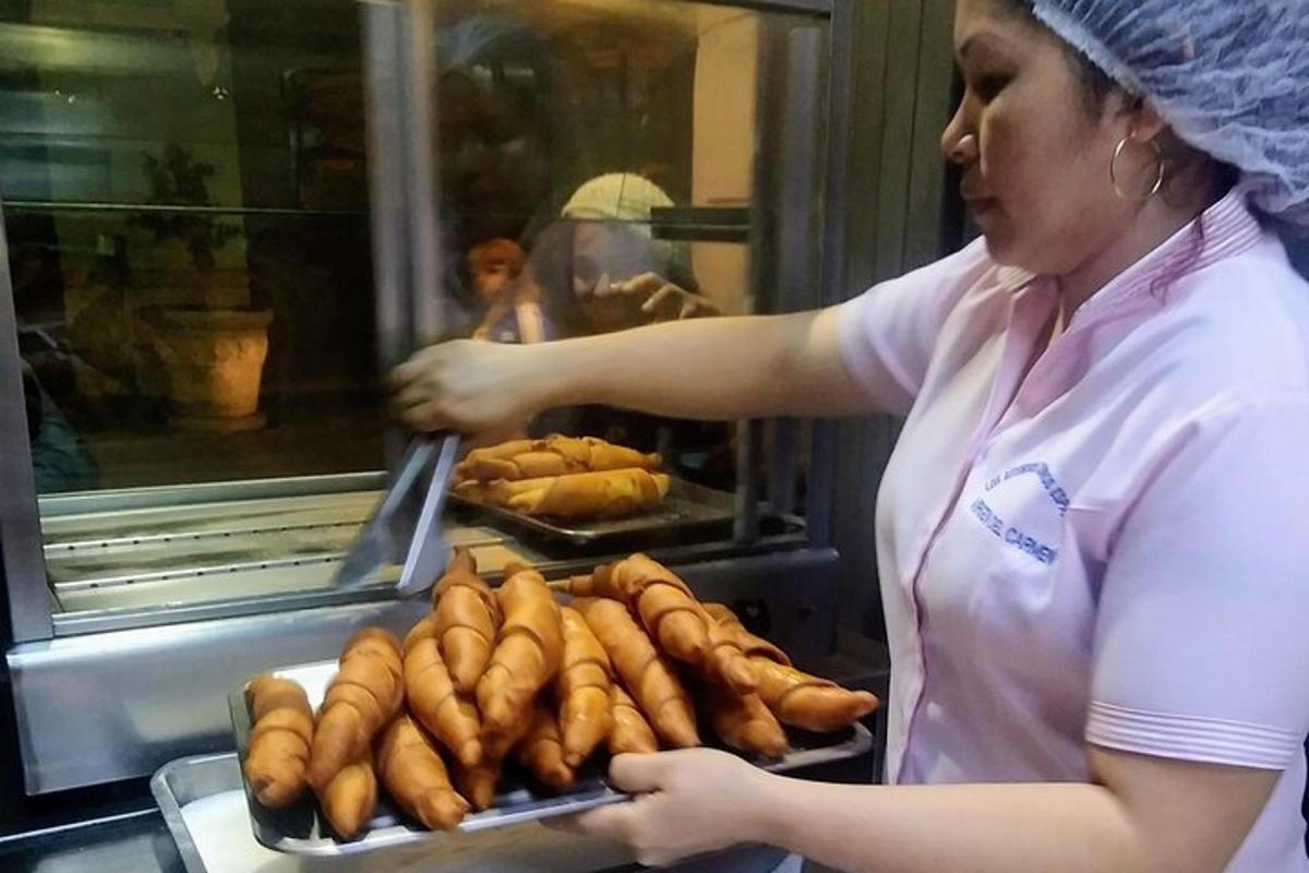 a woman holding a tray of hot dogs