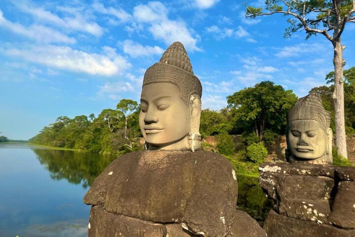 duas grandes estátuas sentadas em uma rocha perto de um lago