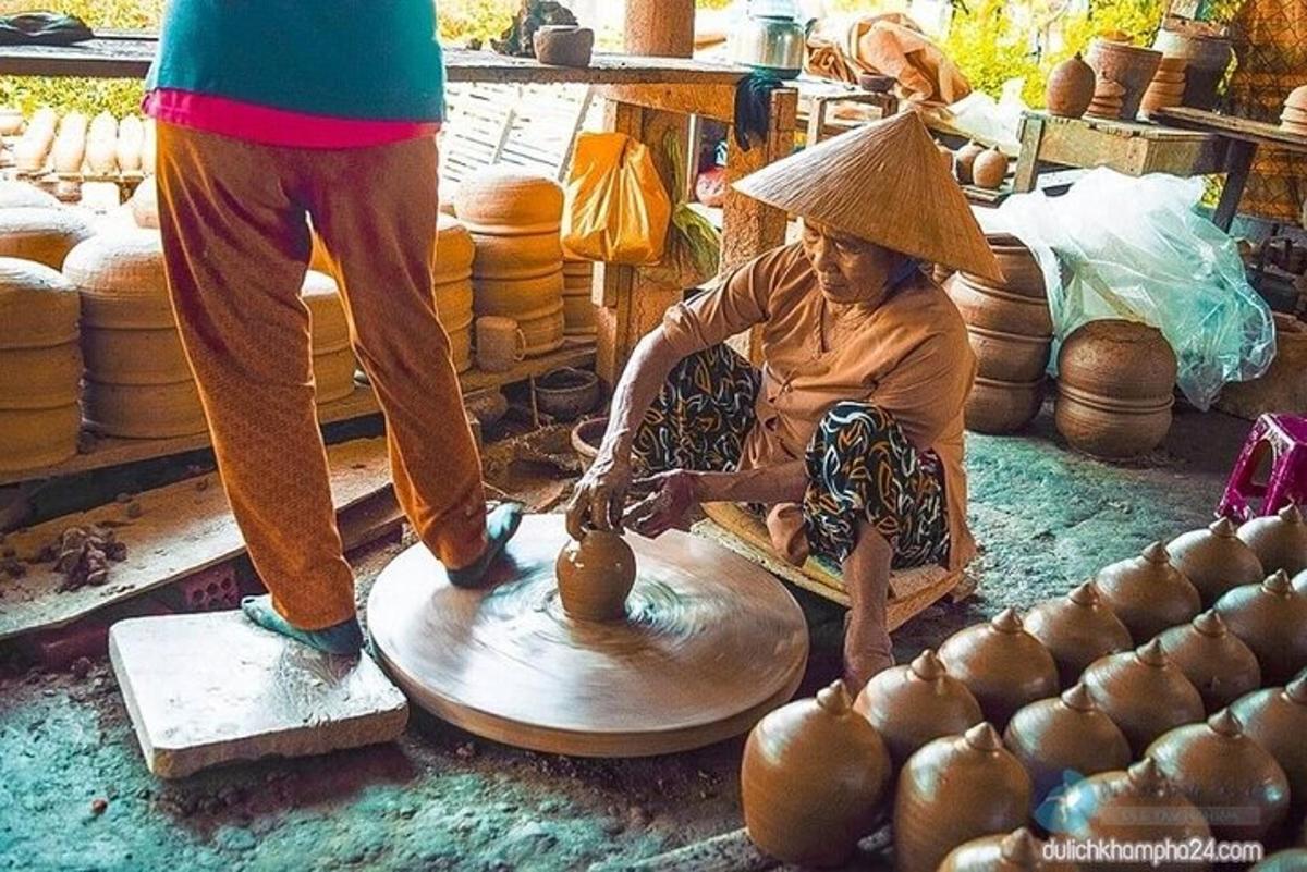 a woman is making a vase on a pottery wheel