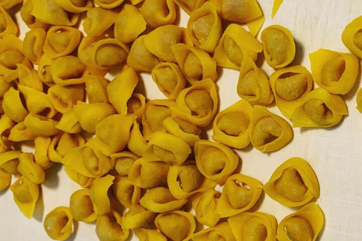 en bunke gul pasta på en hvid overflade