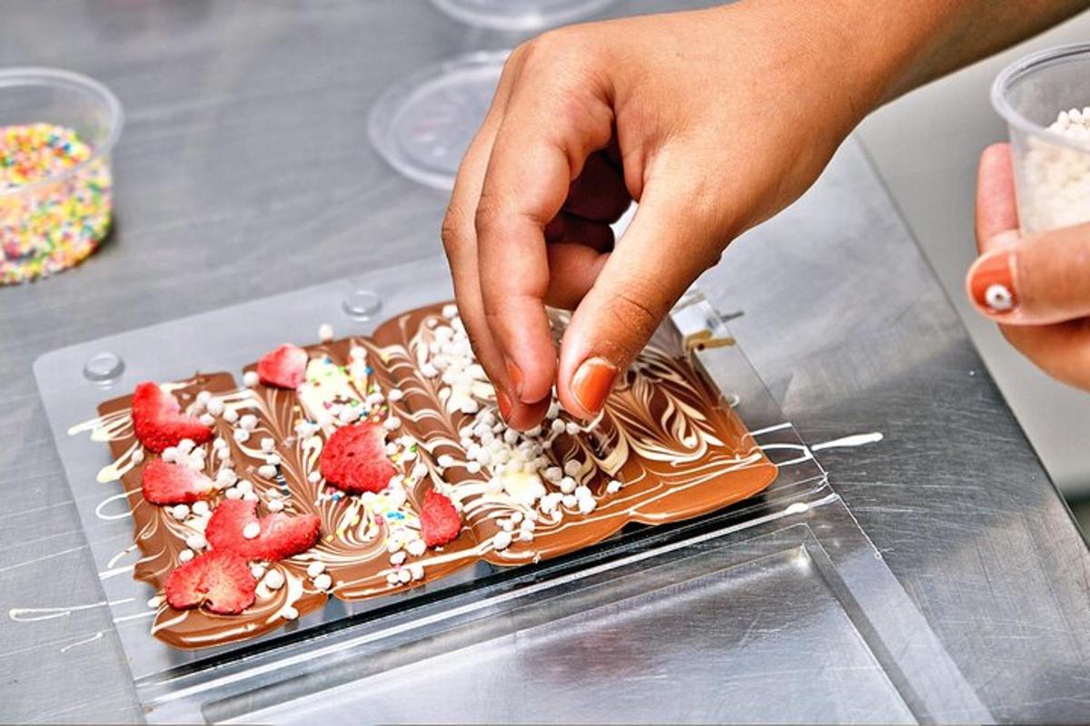 seseorang sedang menghias pencuci mulut dengan strawberi di atasnya