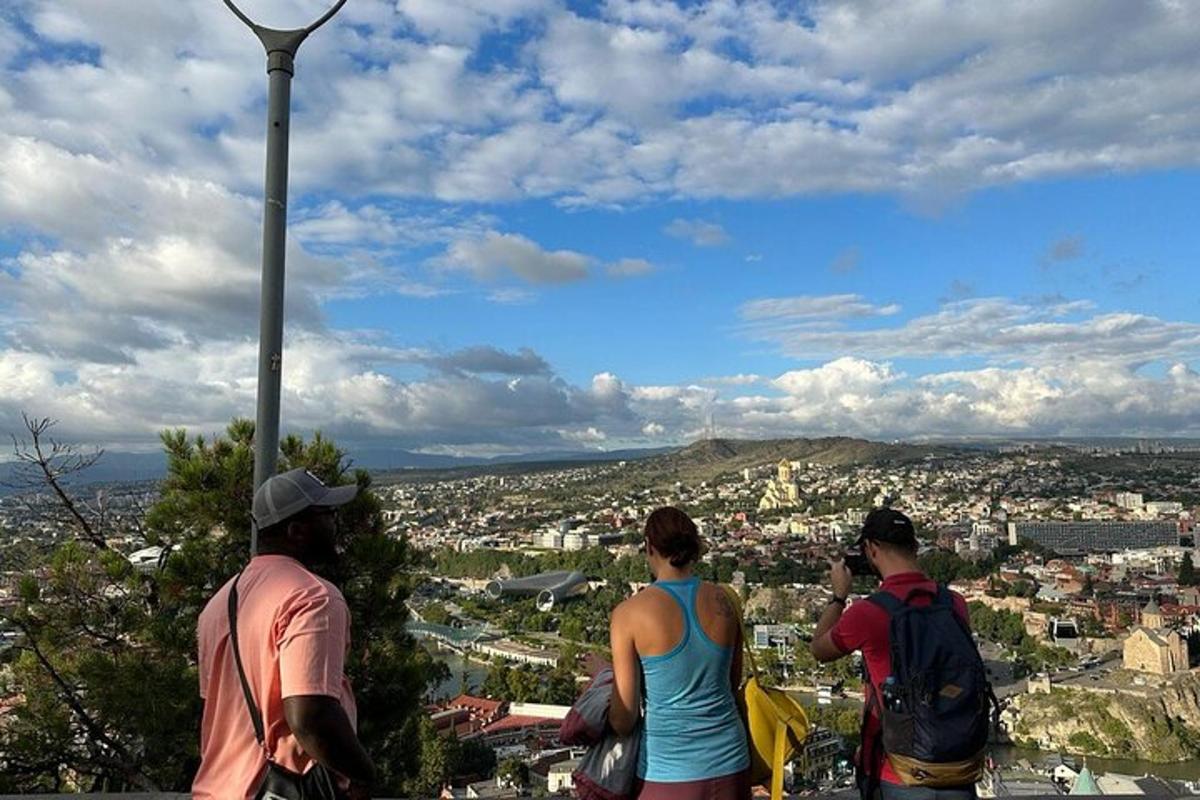 Τρία άτομα στέκονται στην κορυφή ενός πύργου κοιτάζοντας μια πόλη