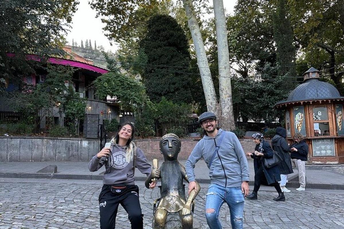 Un hombre y una mujer de pie junto a una estatua