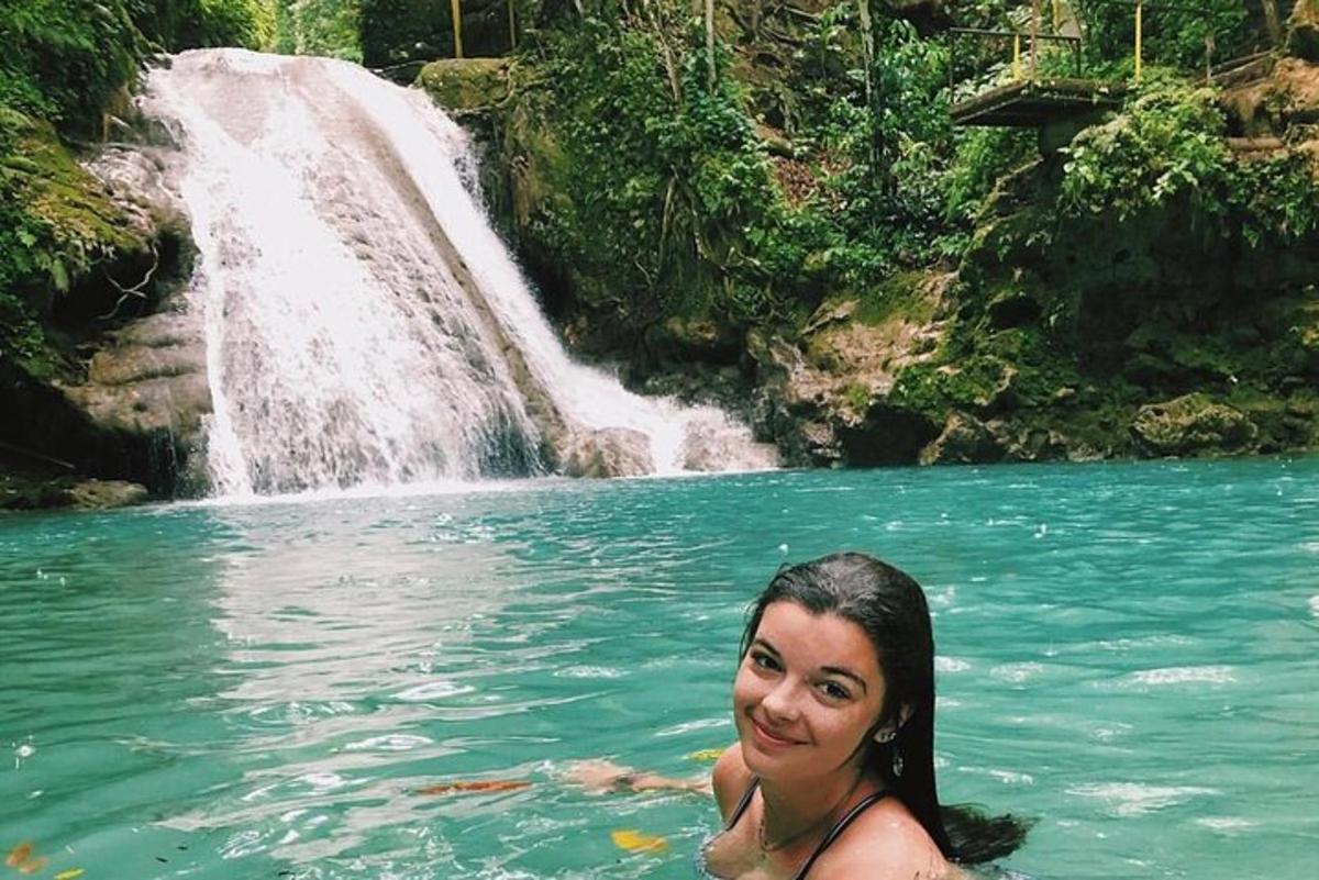 una donna in acqua davanti a una cascata