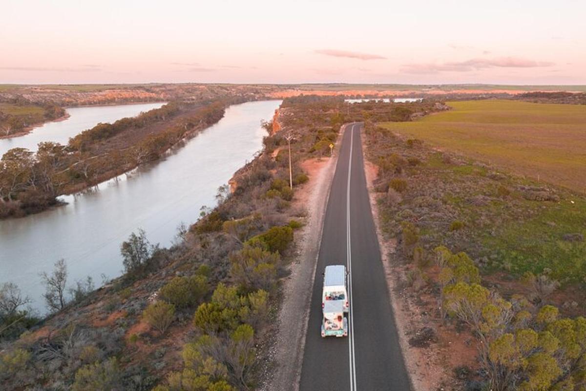 an aerial view of a highway next to a river