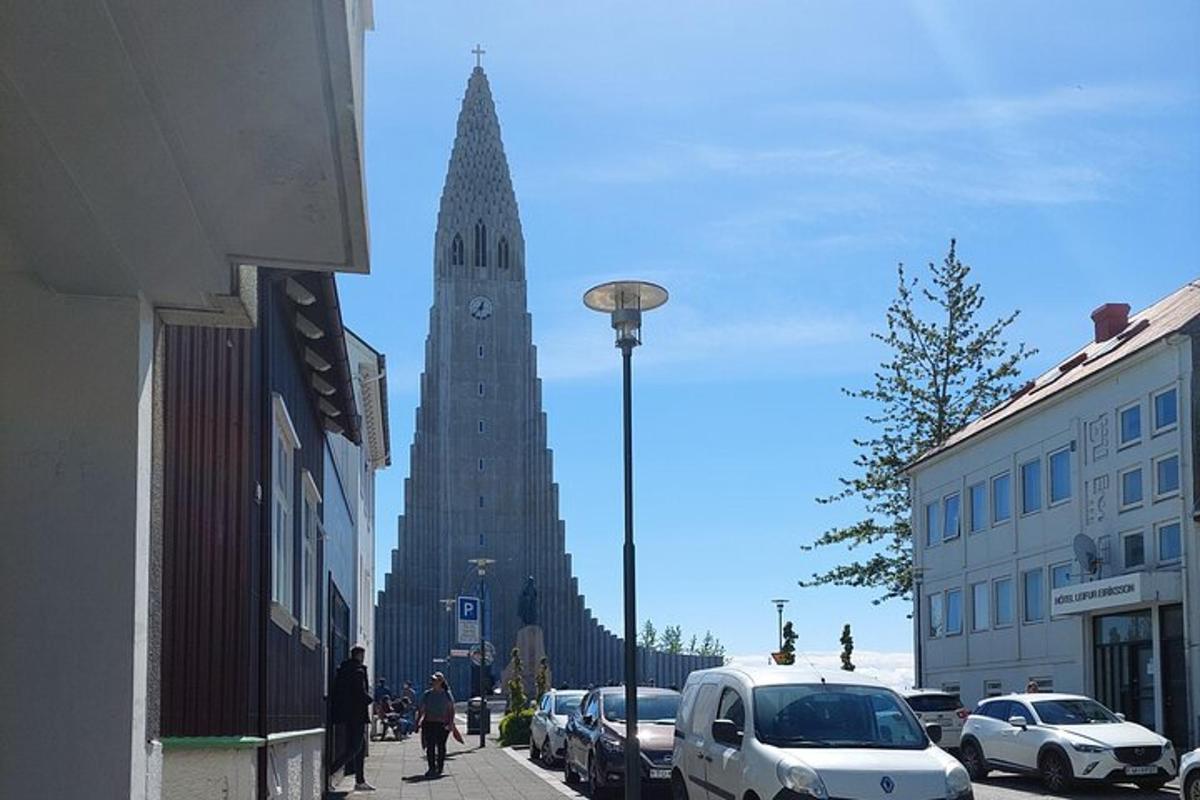 un alto edificio con una torre dell'orologio su una strada cittadina