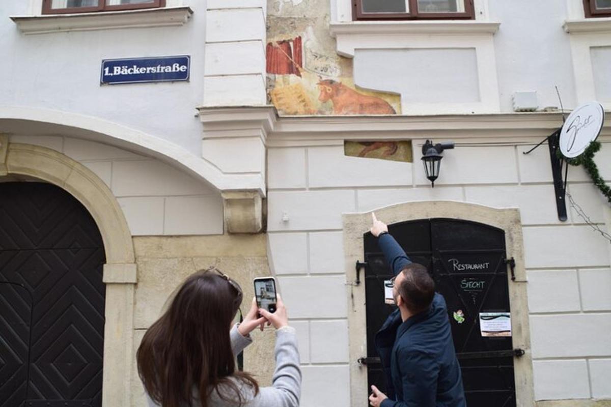 dva lidé fotí budovu mobilním telefonem