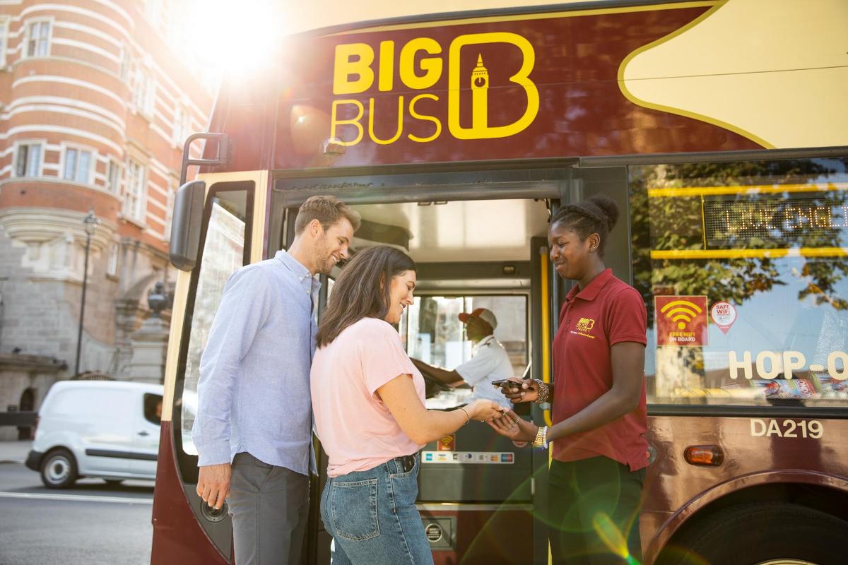 a group of people standing outside of a bus