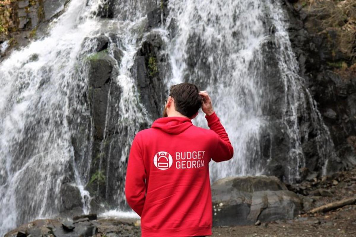 a man standing in front of a waterfall