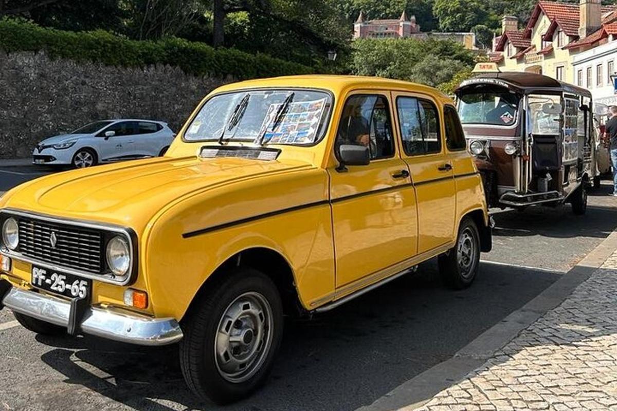 Žluté auto je zaparkované na ulici s nákladním autem