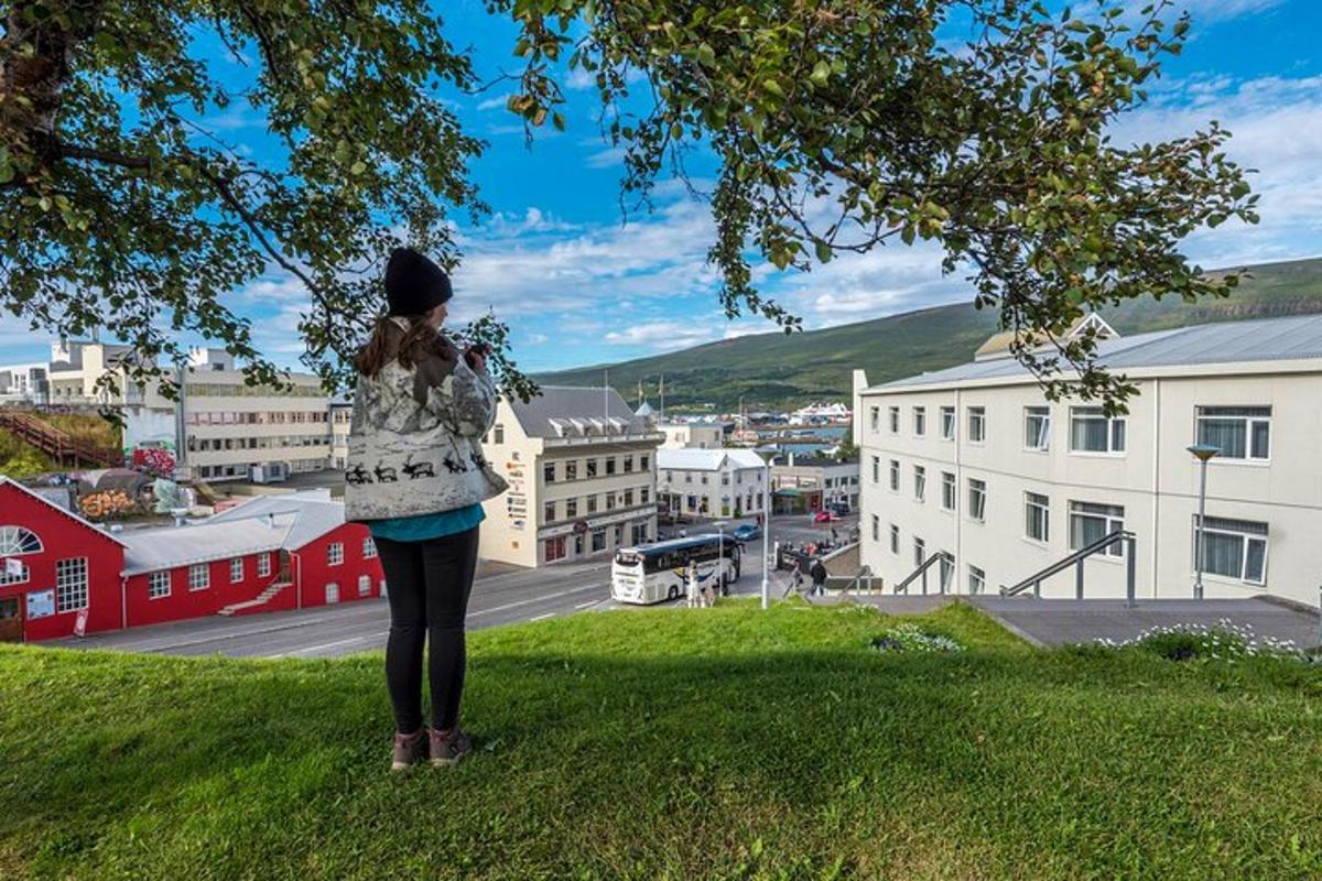 Una mujer parada en una colina mirando una ciudad.