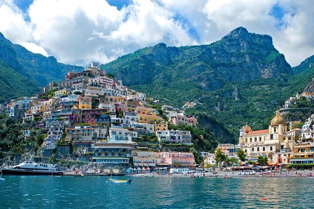 a group of buildings on a hill next to the water