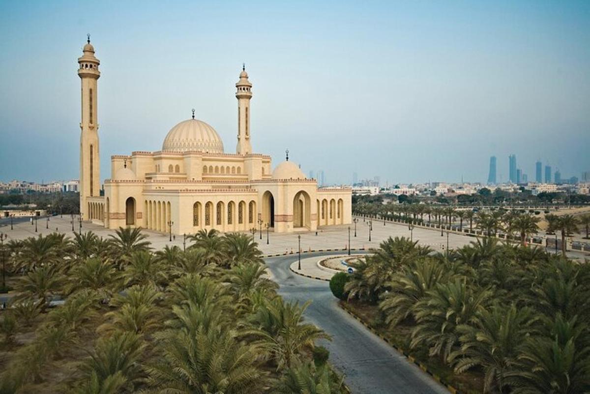 a large building with a mosque with palm trees in front